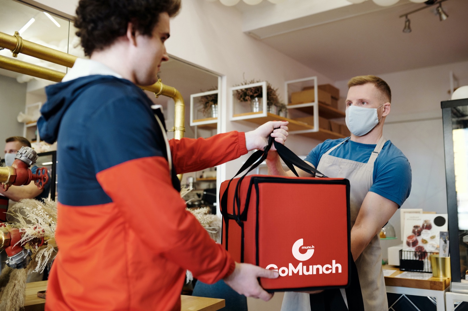 Restaurant handing over a GoMunch delivery bag